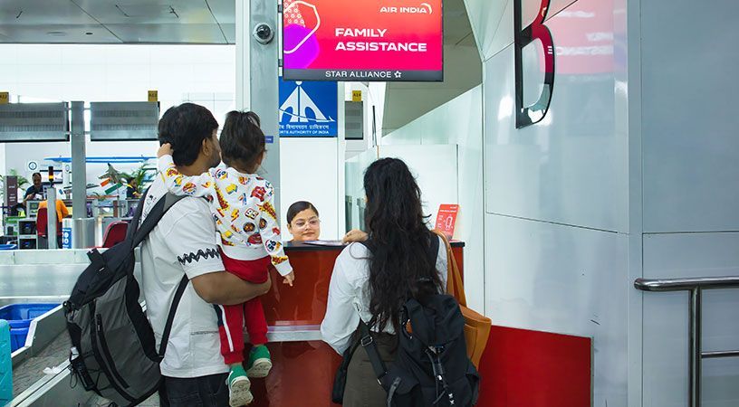 Parents with a young child at an airport family assistance counter.